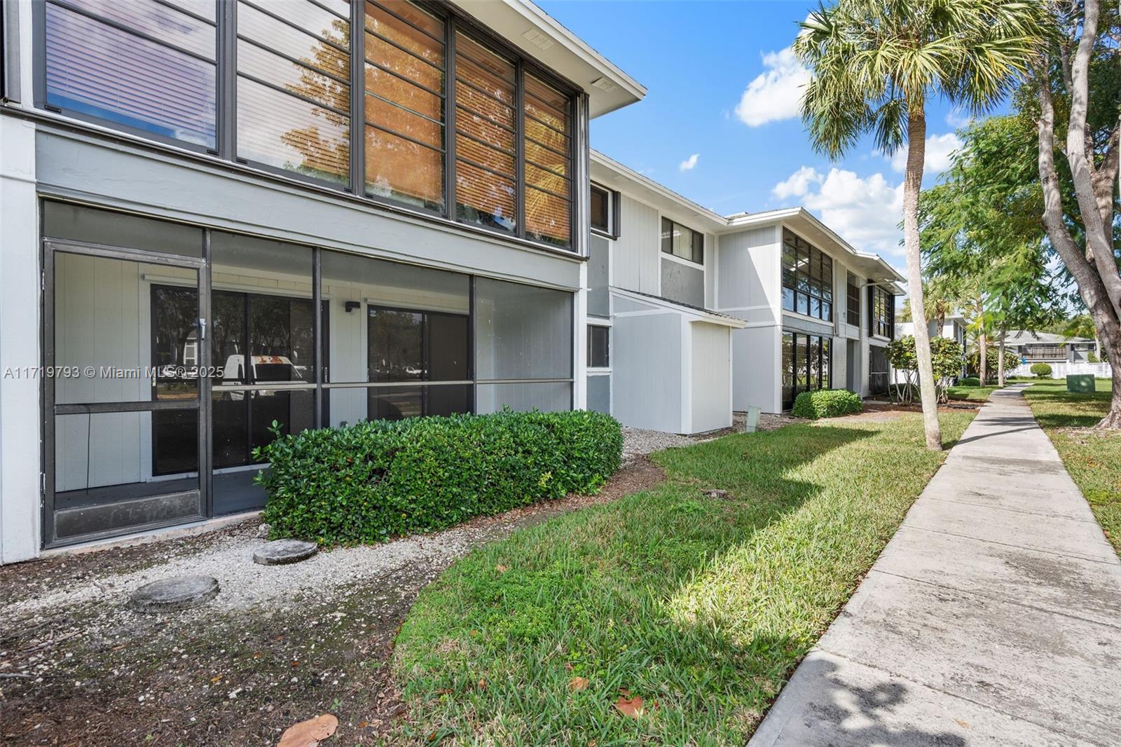 9729 Hammocks Boulevard, Unit 106E Miami, FL 33196 - Photo 25 of 25 front view of a brick house with a yard
