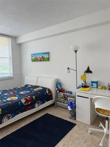 a bedroom with a bed and a desk in it