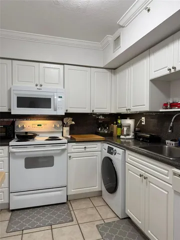 a kitchen with cabinets a sink and appliances