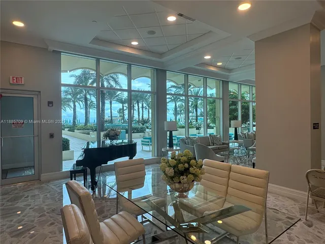 a view of a dining room with furniture large windows and wooden floor