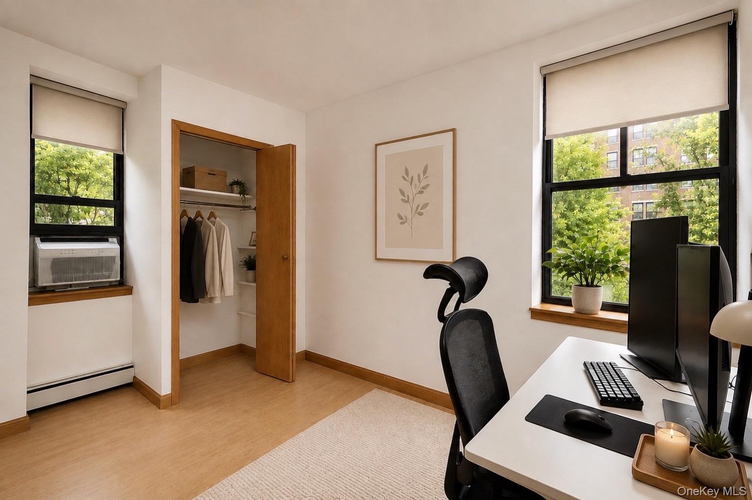 Built-in closet with shelving, and large windows with roller shades.