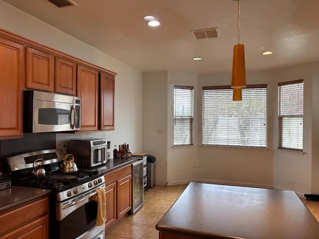 a kitchen with stainless steel appliances granite countertop a stove a sink and a microwave