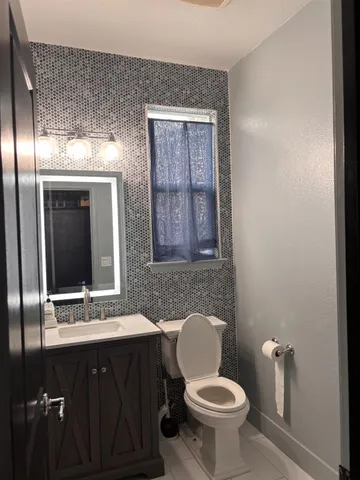 a bathroom with a toilet a sink and mirror