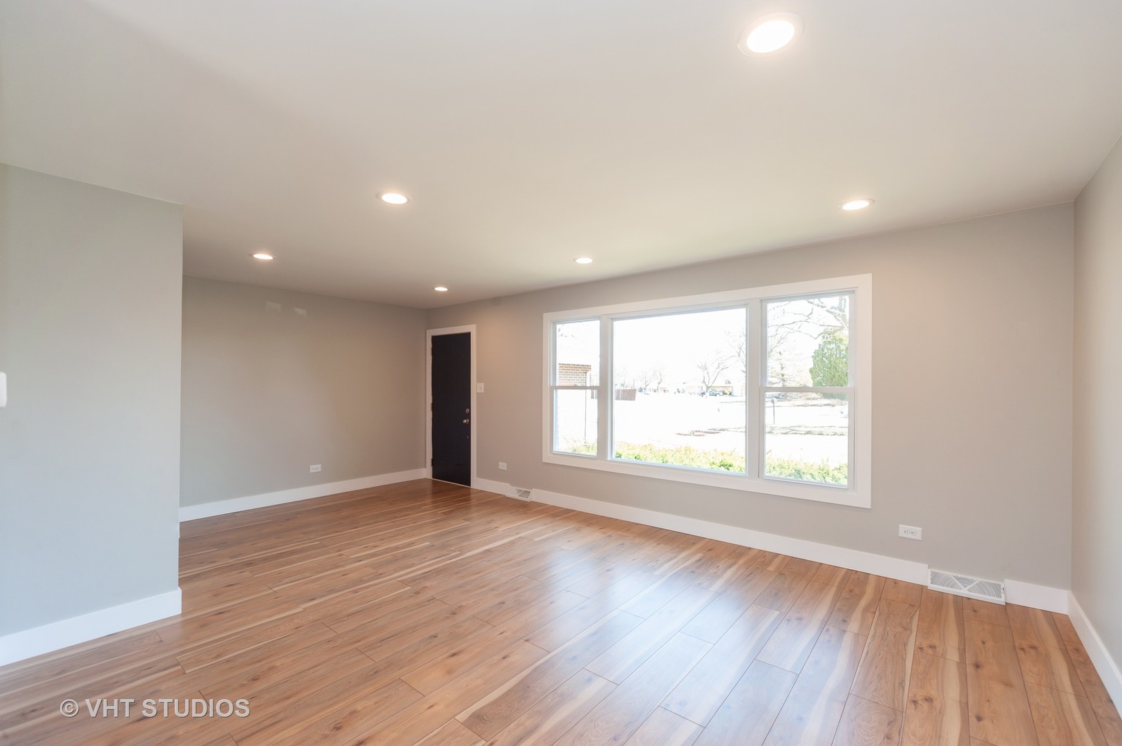 608 Willow Road Matteson, IL 60443 - Photo 2 of 15 an empty room with wooden floor and windows