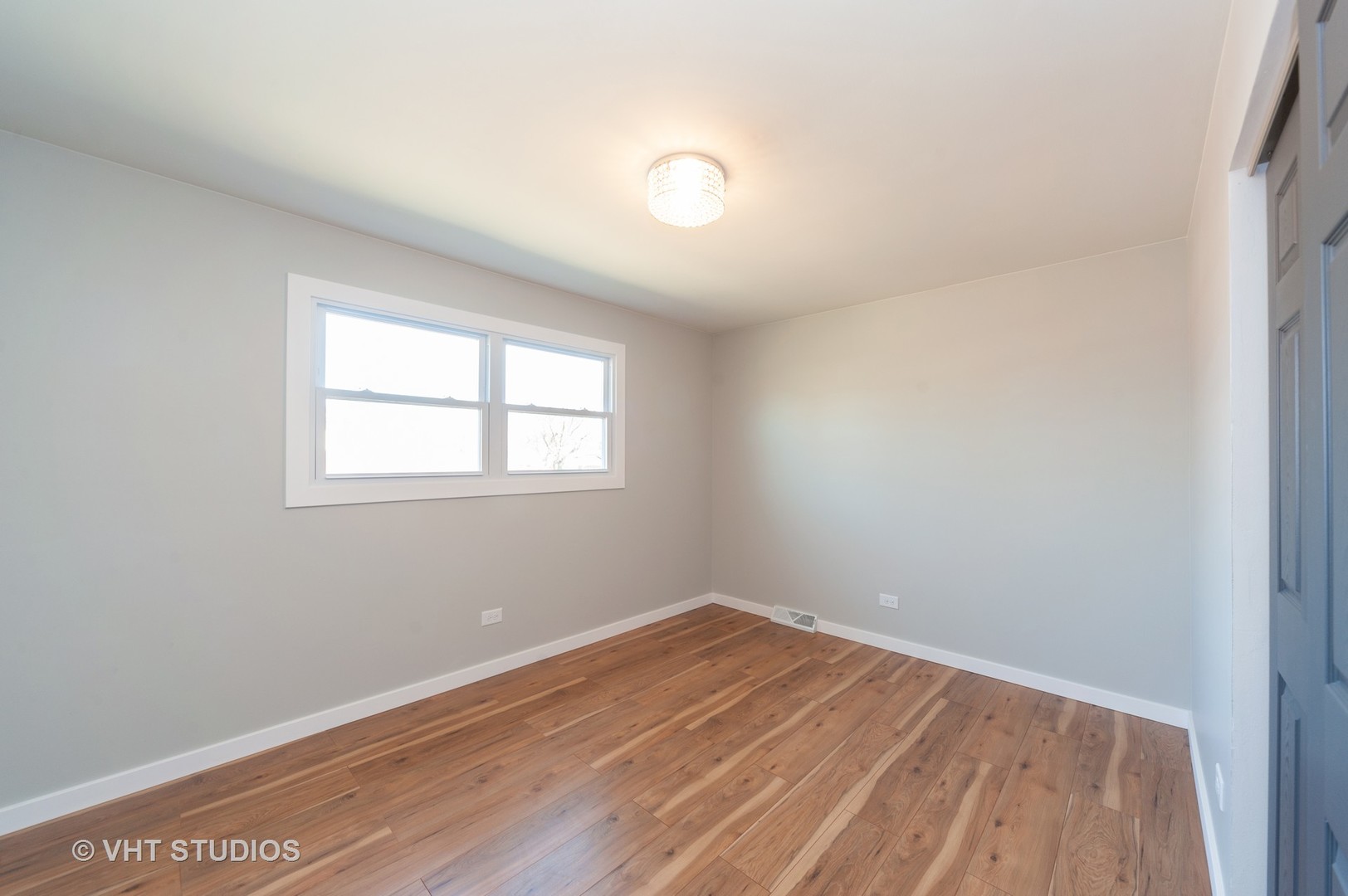 608 Willow Road Matteson, IL 60443 - Photo 9 of 15 an empty room with wooden floor and windows