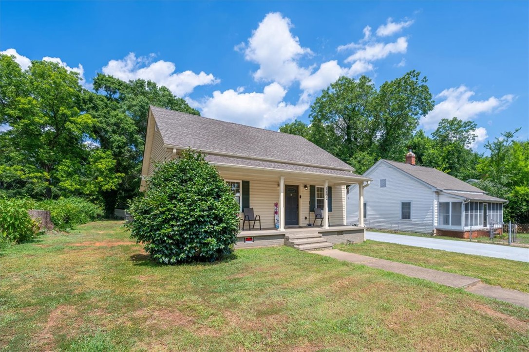 1102 West End Avenue Anderson, SC 29625 - Photo 4 of 28 A well-maintained single-story residence with a welcoming front porch, nestled amidst mature shade trees.