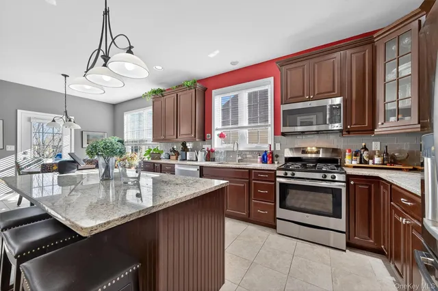 a kitchen with stainless steel appliances granite countertop a stove top oven a sink dishwasher and cabinets