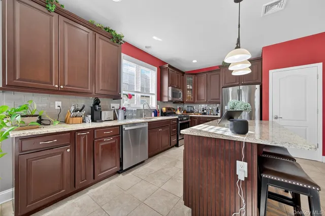 a kitchen with a stove window cabinets and stainless steel appliances