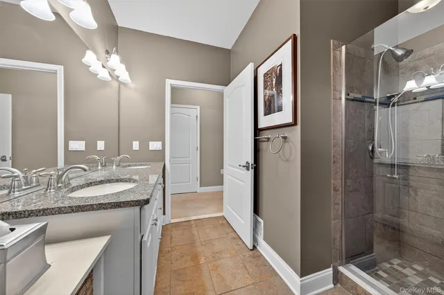 a bathroom with a granite countertop sink mirror and shower