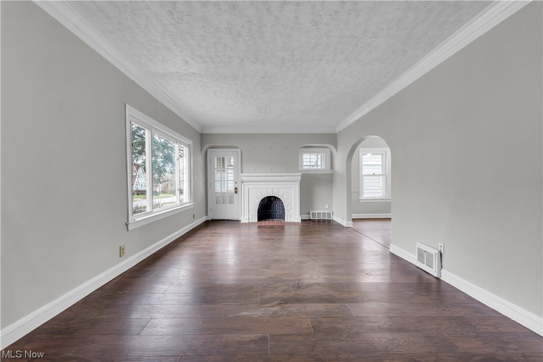 1499 Sherbrook Road South Euclid, OH 44121 - Photo 26 of 41 Unfurnished living room featuring dark hardwood / wood-style floors, a textured ceiling, and crown molding