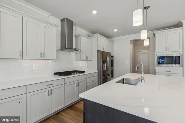 a kitchen with a sink a refrigerator and cabinets