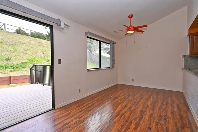 a view of a livingroom with wooden floor and a ceiling fan