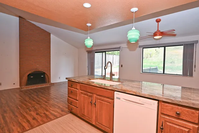 a kitchen with stainless steel appliances granite countertop a sink a granite counter tops and a wooden floors