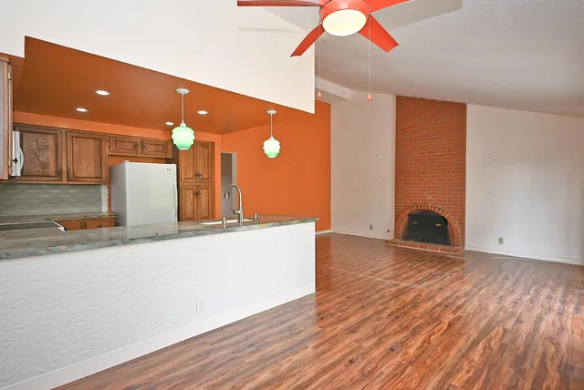 a view of a livingroom with wooden floor and staircase
