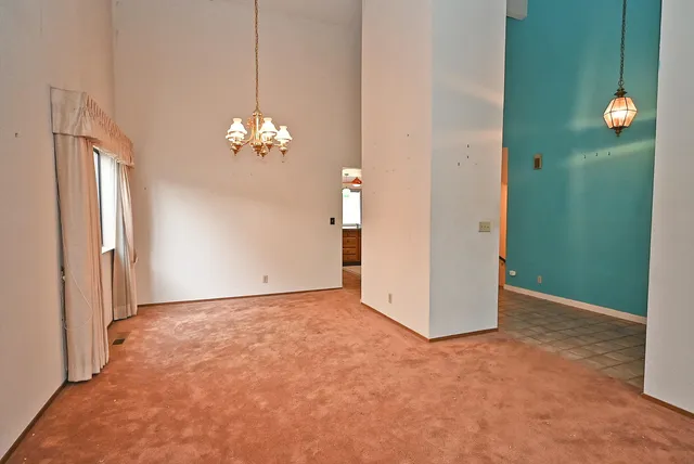 a view of a chandelier in big room and a bathroom