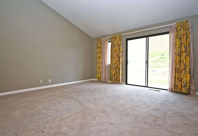 an empty room with windows and city view