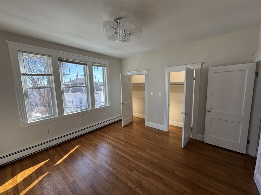 84 Tudor Street, Unit 6 Chelsea, MA 02150 - Photo 13 of 14 a view of an empty room with wooden floor and a window