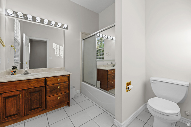 4117 North Wolf Ridge Circle Eden, UT 84310 - Photo 40 of 63 Bathroom featuring a rich wood-finish vanity with an integrated sink, a large wall-mounted mirror, a modern vanity light fixture, a shower-tub combination with a sliding glass door, and white square tile flooring