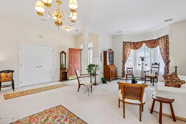 a living room with patio furniture and a chandelier