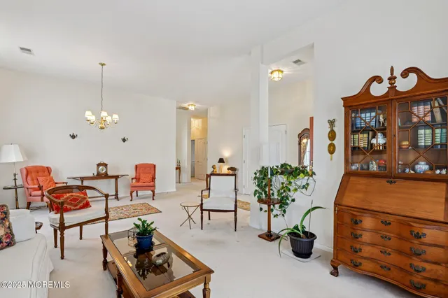 a living room with furniture flowers and a chandelier
