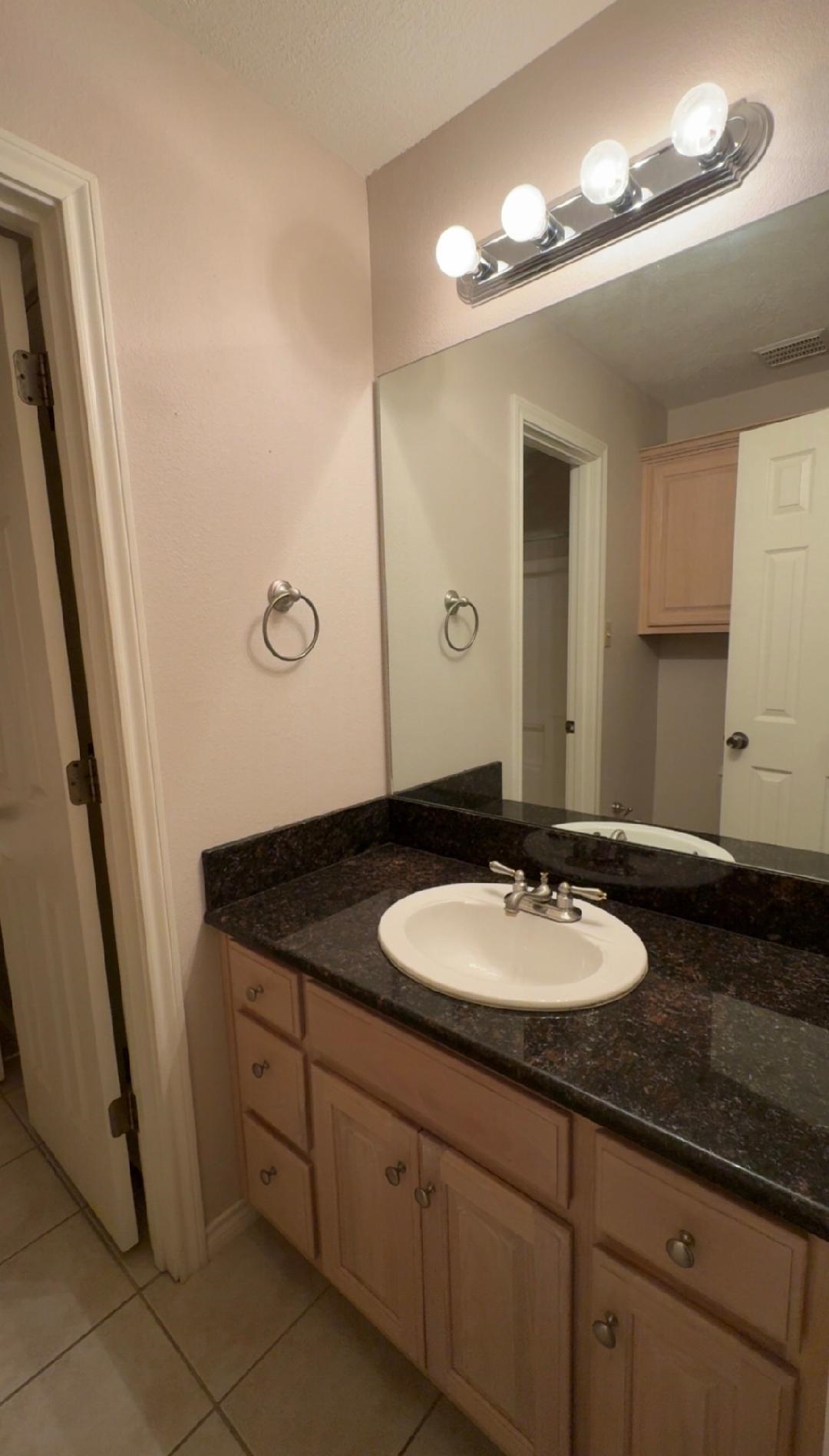 4665 Glen Oaks Circle Beaumont, TX 77708 - Photo 14 of 20 a bathroom with a granite countertop sink a mirror and a