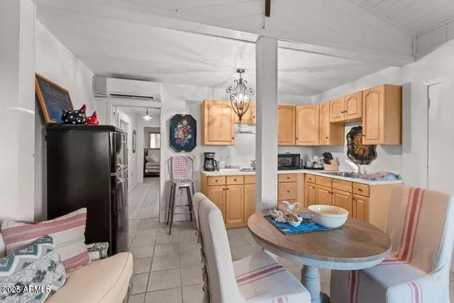 a living room with stainless steel appliances furniture a table and chairs