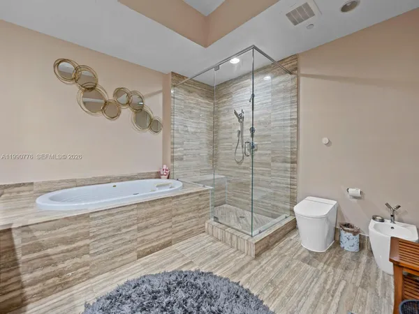 a bathroom with a granite countertop bathtub sink vanity mirror and toilet