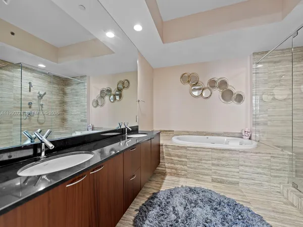 a bathroom with a granite countertop sink a mirror and a shower