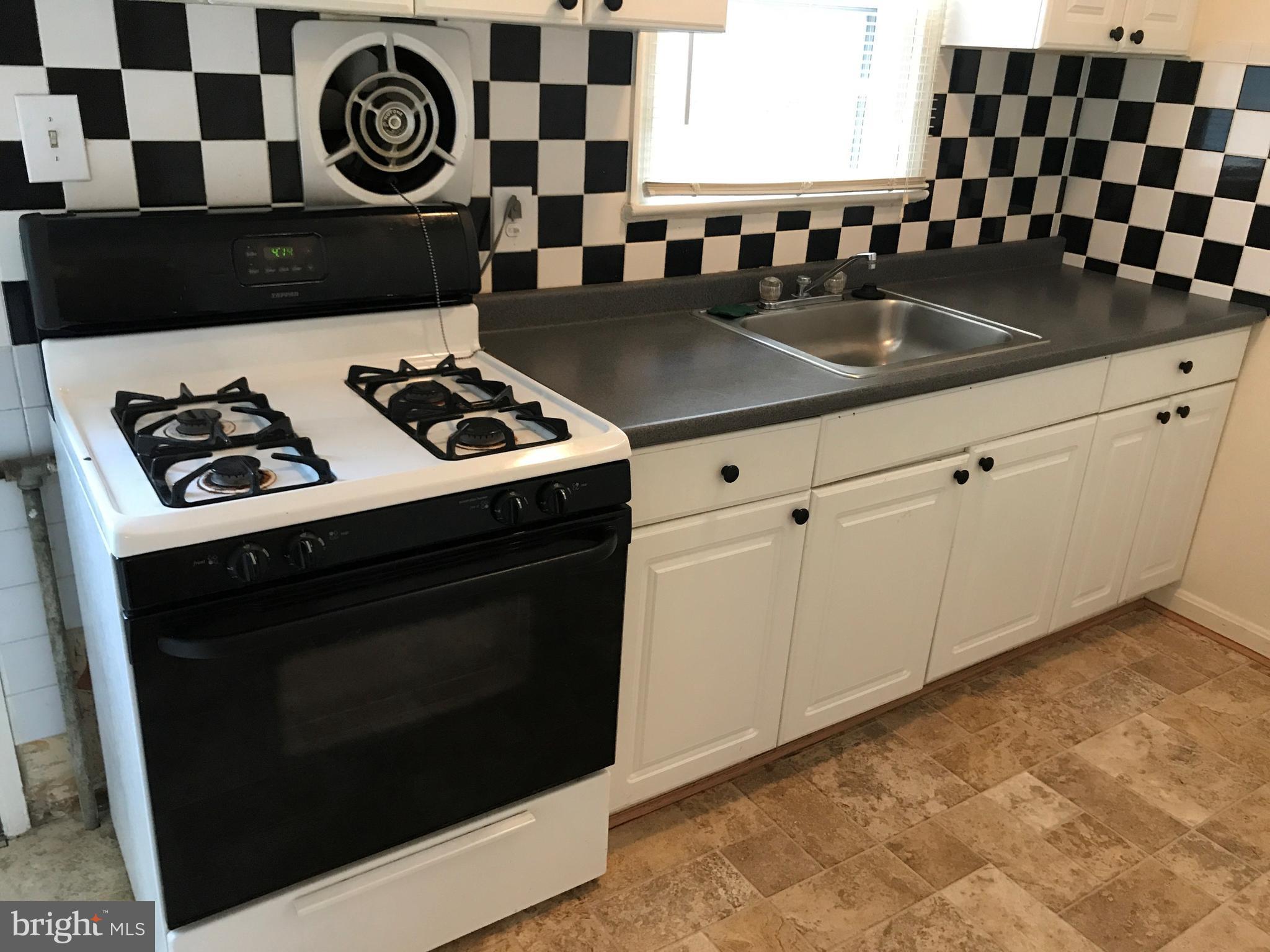 3325 Clay Street Silver Spring, MD 20902 - Photo 5 of 7 a kitchen with granite countertop a stove a microwave a sink and cabinets