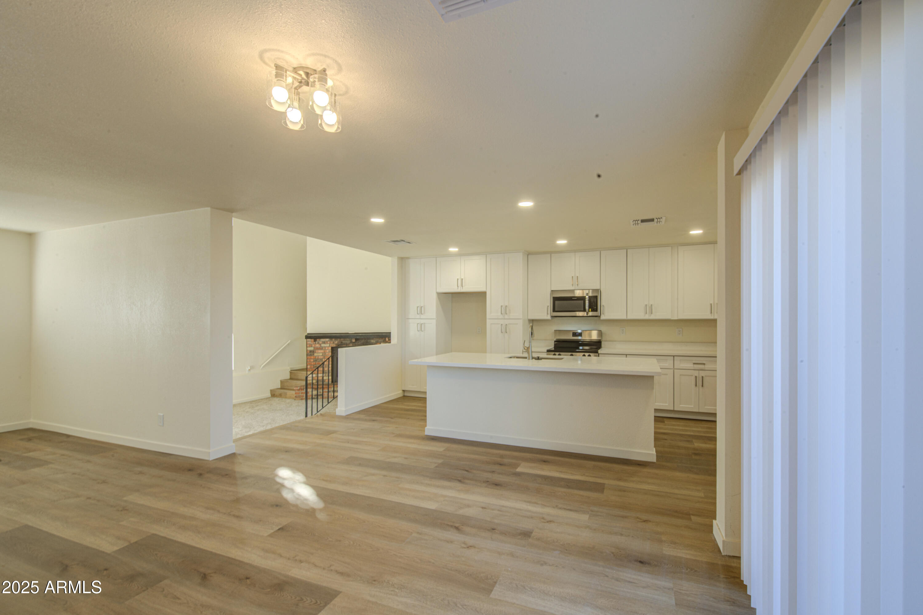 25450 West Clayton Road Casa Grande, AZ 85193 - Photo 19 of 80 a view of a kitchen with kitchen island a sink wooden floor and a living room view