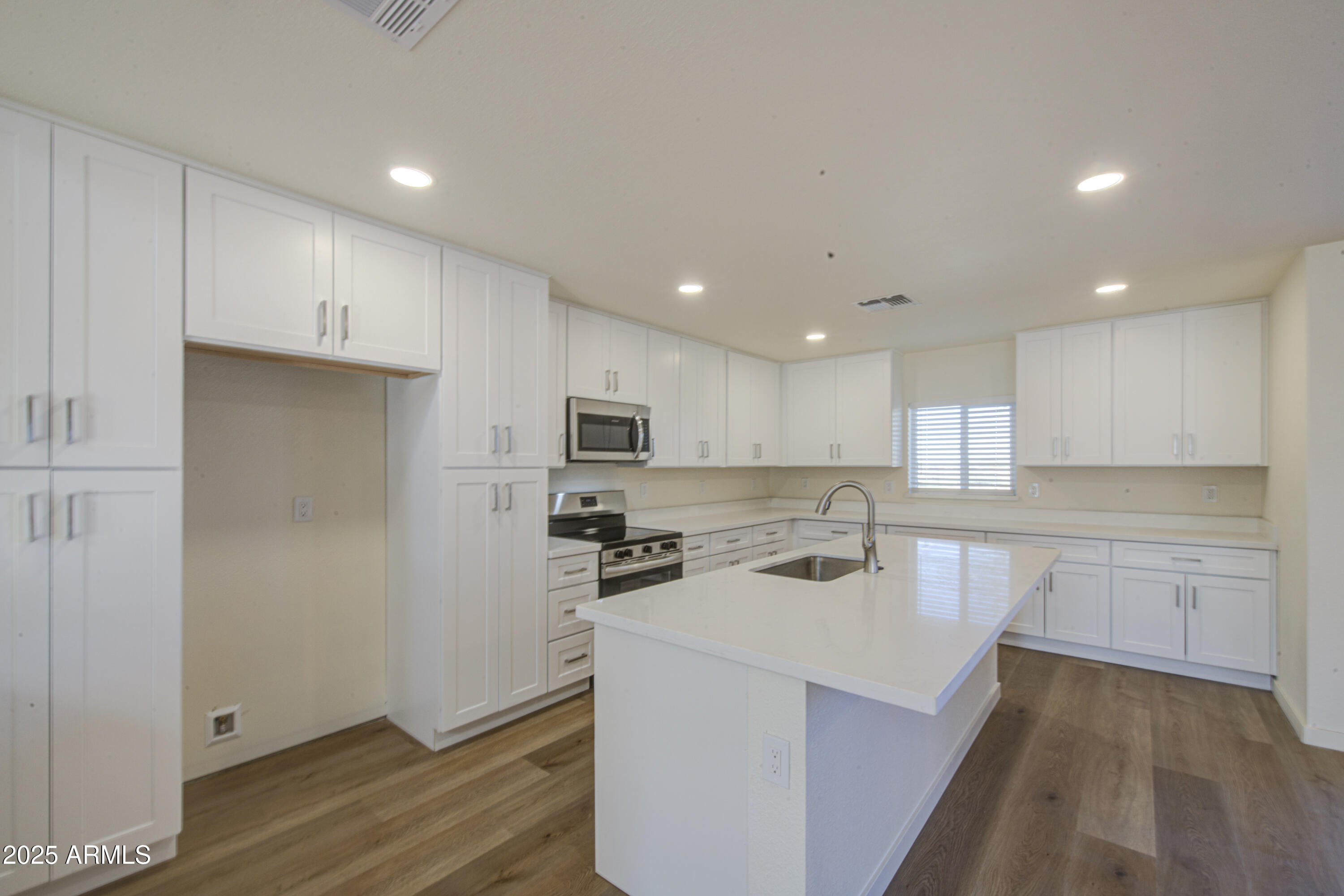 25450 West Clayton Road Casa Grande, AZ 85193 - Photo 20 of 80 a kitchen with kitchen island a sink a stove a refrigerator and white cabinets