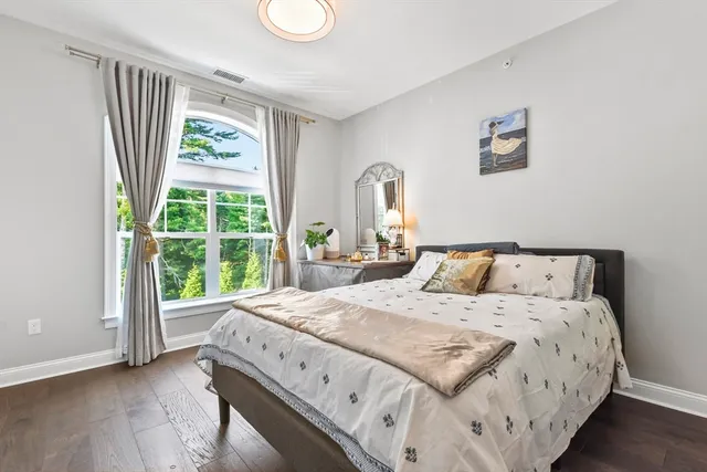 a large bed sitting in a bedroom next to a window