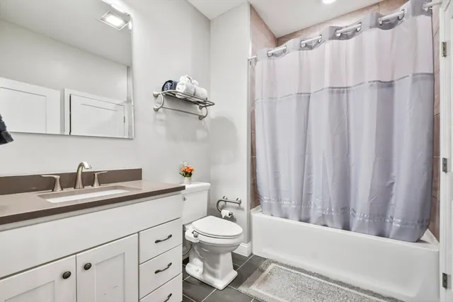 a bathroom with a granite countertop sink toilet a mirror and shower