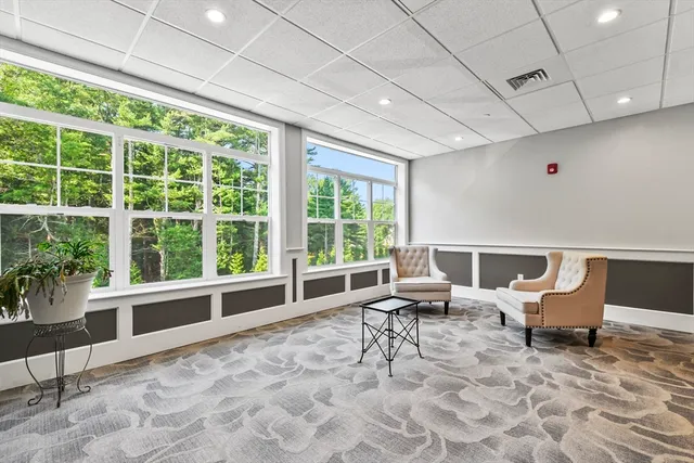 a living room with furniture and large windows