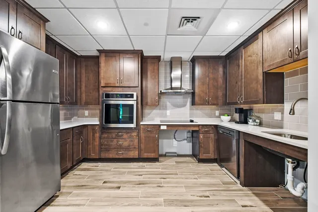 a kitchen with stainless steel appliances granite countertop a refrigerator and a stove top oven