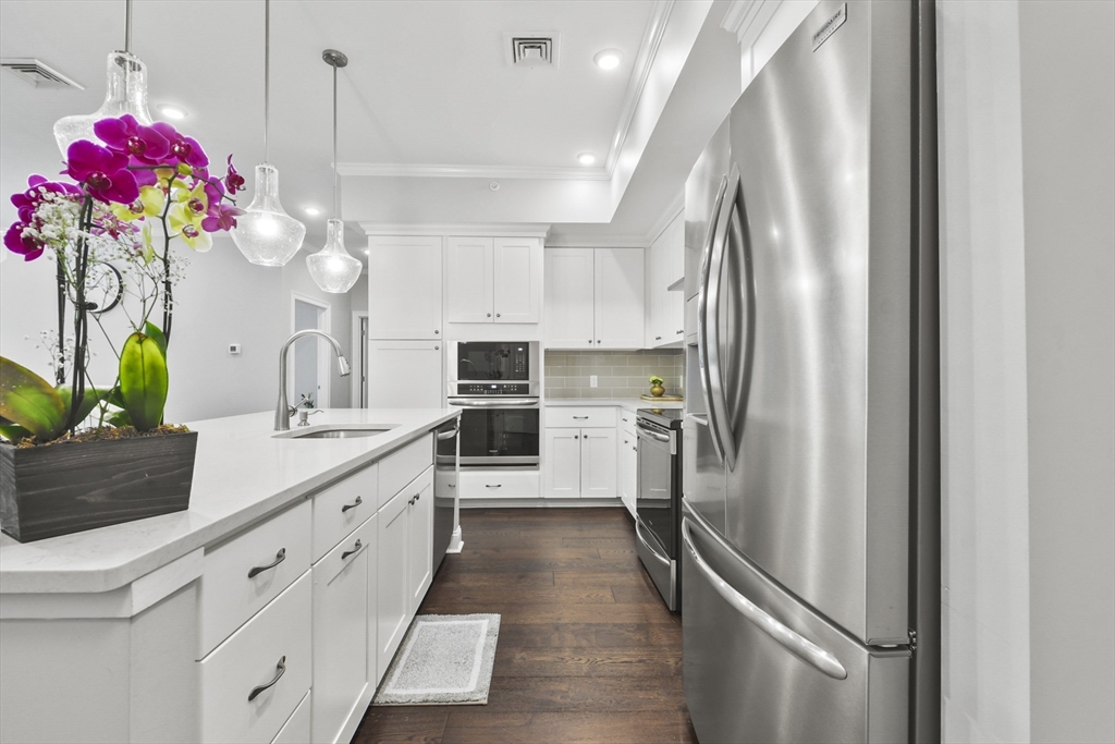 635 Old Post Road, Unit 303 Sharon, MA 02067 - Photo 4 of 33 a kitchen with granite countertop a refrigerator and a sink