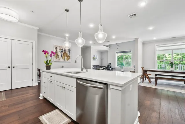 a large kitchen with kitchen island a stove a wooden floor and a large window