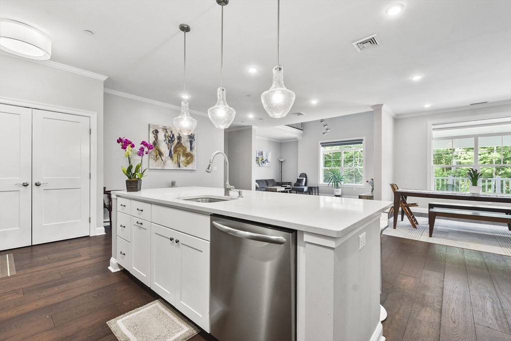 635 Old Post Road, Unit 303 Sharon, MA 02067 - Photo 6 of 33 a large kitchen with kitchen island a stove a wooden floor and a large window