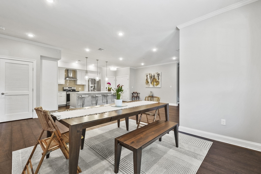 635 Old Post Road, Unit 303 Sharon, MA 02067 - Photo 9 of 33 a kitchen with a dining table chairs and wooden floor