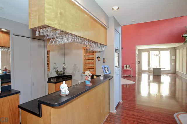a view of an empty room with wooden floor and a ceiling fan
