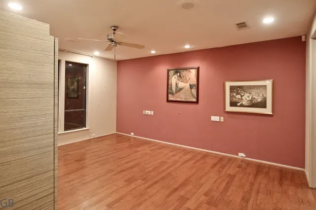 a view of a livingroom with wooden floor and a ceiling fan