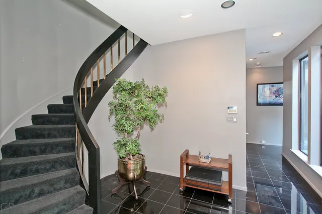 a view of a hallway with wooden floor and stairs