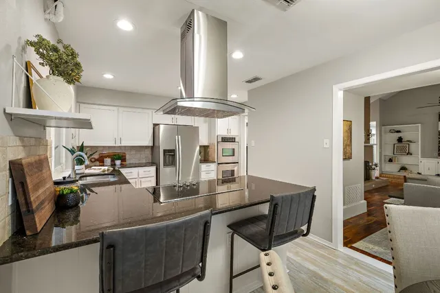 a kitchen with stainless steel appliances granite countertop a stove refrigerator and cabinets