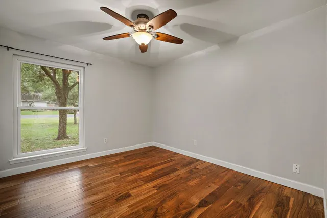 an empty room with a window and a fan