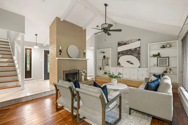 a living room with furniture a fireplace and wooden floor
