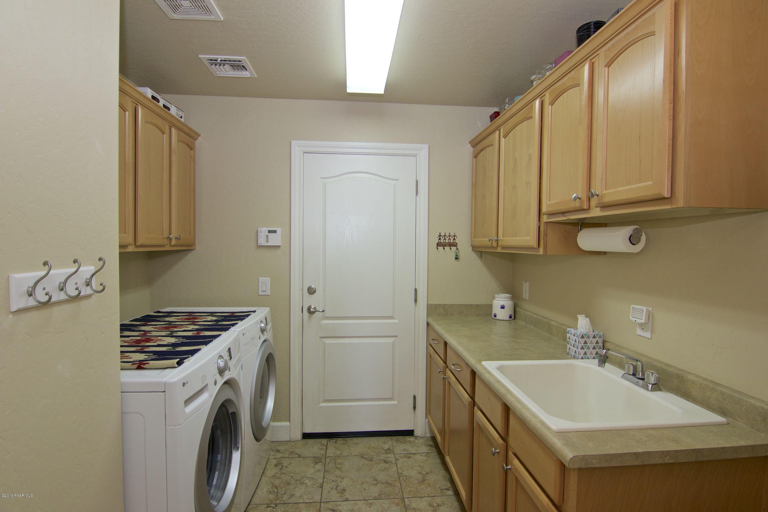 1157 Rusty Nail Road Prescott Valley, AZ 86314 - Photo 14 of 45 a bathroom with a sink a washer and dryer