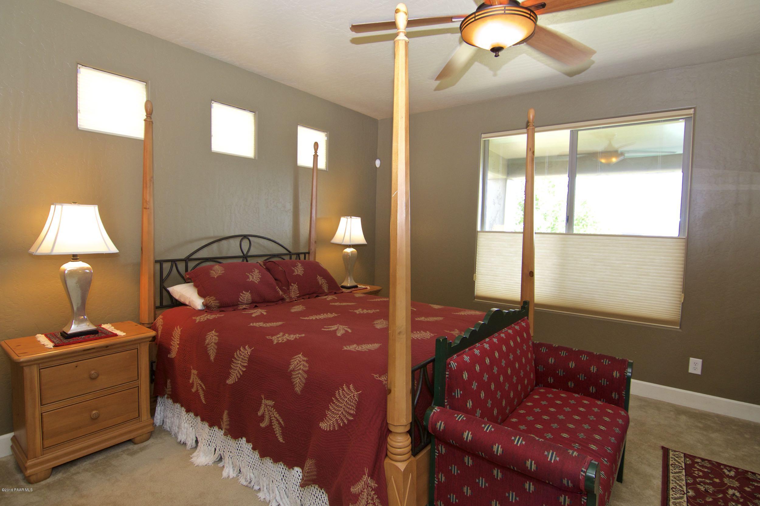 1157 Rusty Nail Road Prescott Valley, AZ 86314 - Photo 17 of 45 a bedroom with a bed and a chandelier
