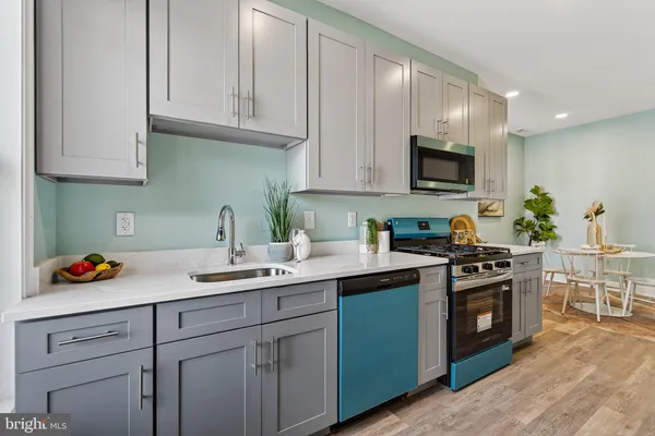 a kitchen with stainless steel appliances granite countertop a sink stove and cabinets