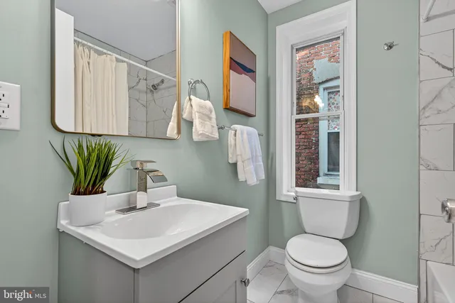 a bathroom with a toilet sink and mirror