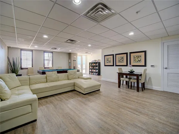 a living room with furniture a table and wooden floor
